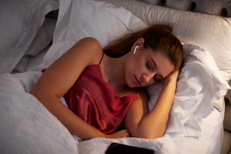 Woman sleeping with earbuds