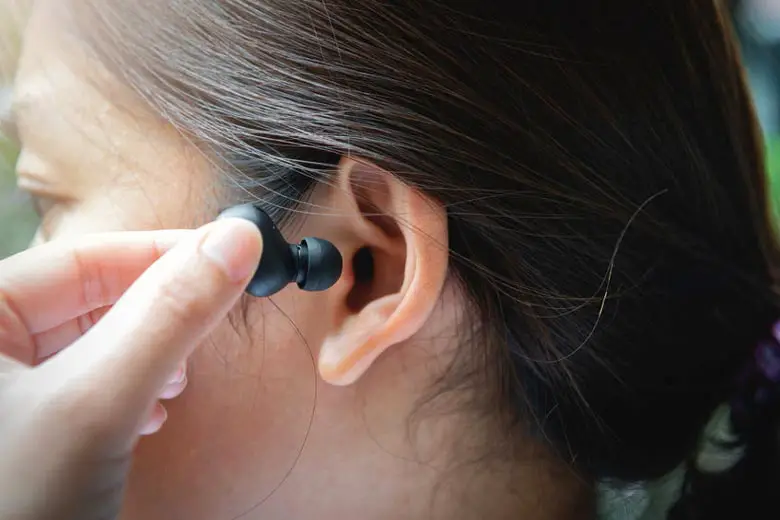 Woman using uncomfortable earbuds