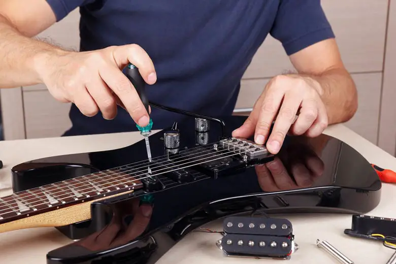 Man changing guitar pickups